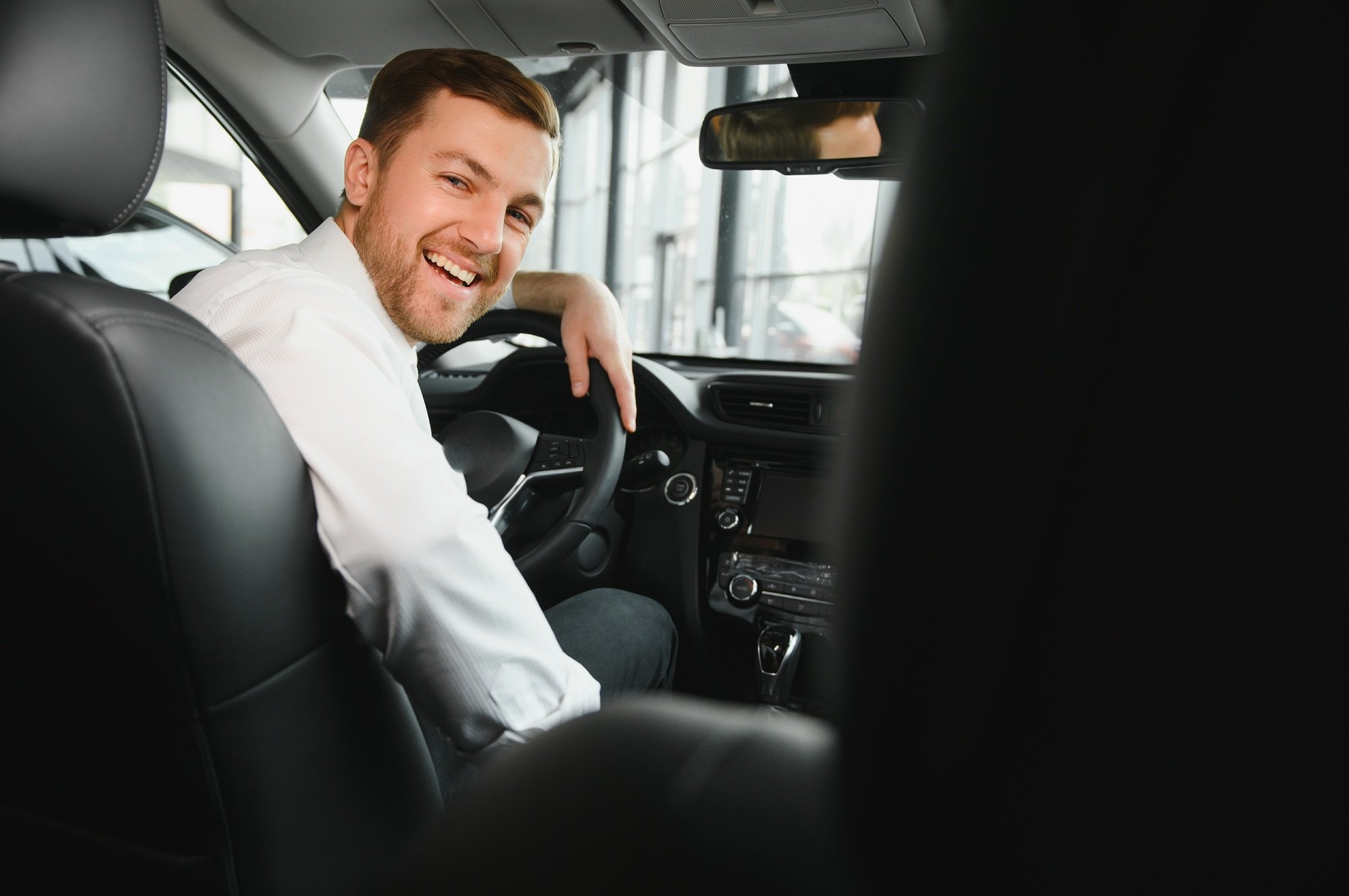 Taxi driver smiling while turning over to the backseat looking talking with clients. Taxi driver smiling while turning over to the backseat looking talking with clients.