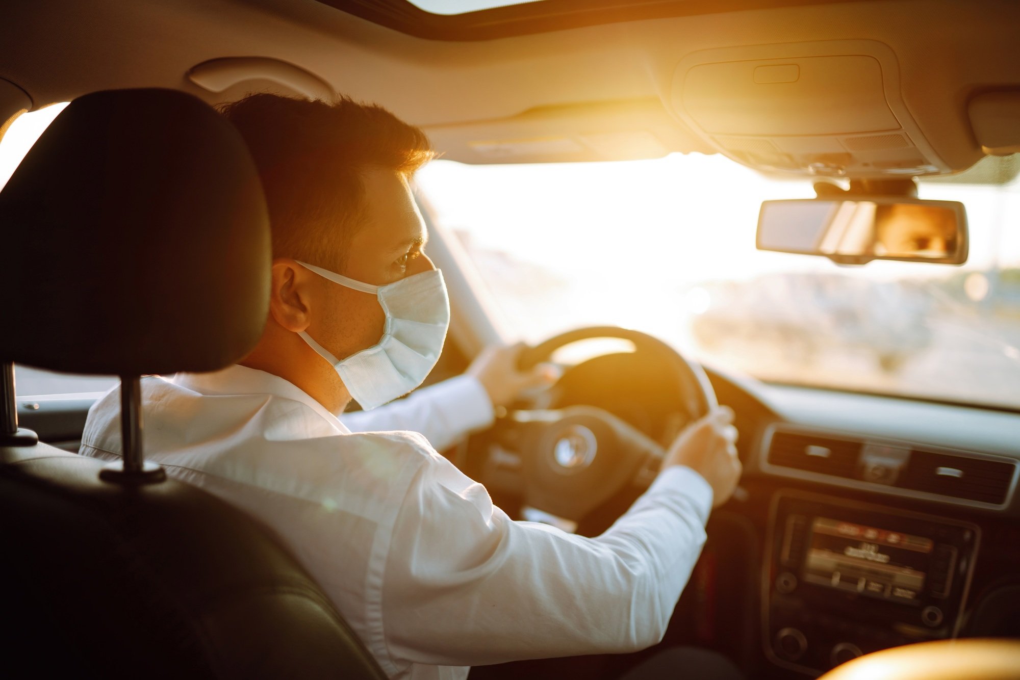 Man driving a car wearing on a medical mask during an epidemic, a driver- taxi in a mask. Covid-2019